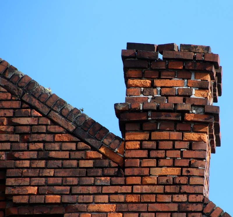 Damaged chimney on an Melissa home showing cracks and missing mortar